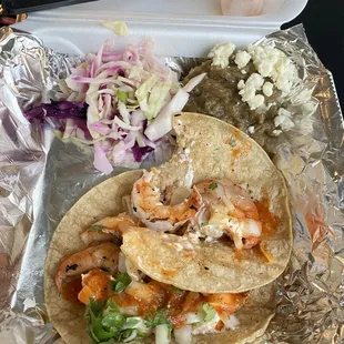 a tray of tacos and salad