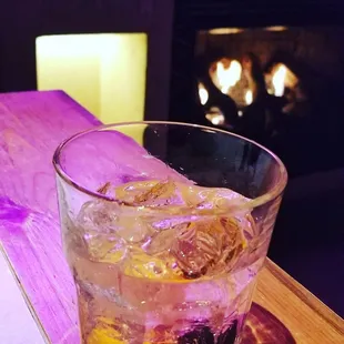 Mezcal old fashioned with the fireplace in the backdrop