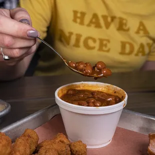a bowl of chili being dipped with a spoon