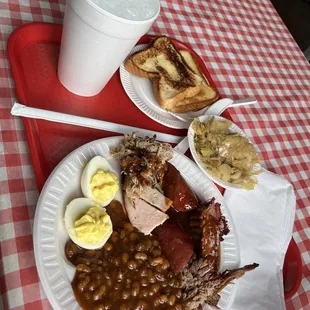 ows a plate of meat, beans, and eggs