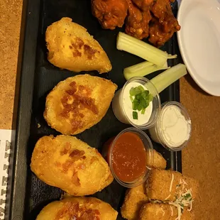 a tray of chicken wings and dipping sauces