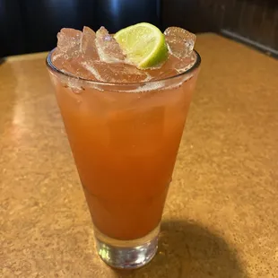 a cocktail with a lime slice on the rim