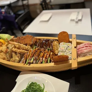 a wooden boat filled with different types of sushi