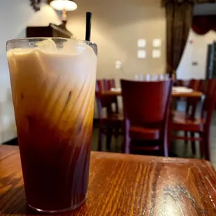 a glass of iced coffee on a table
