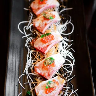 a long rectangular plate of raw fish