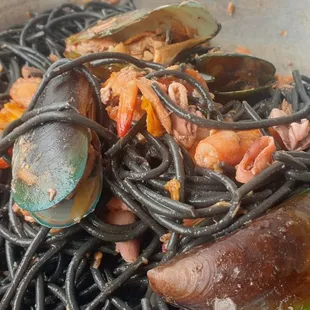 a bowl of noodles with musselling and clams