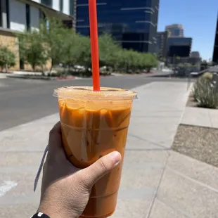 a hand holding a cup of iced coffee