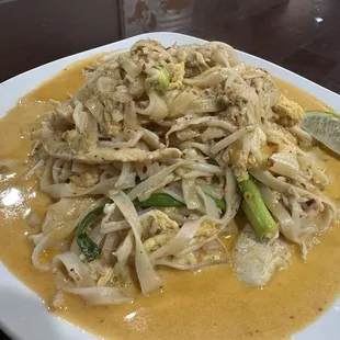 Pad Thai Curry: A rich blend of coconut milk, bold spices, and tender noodles topped with fresh herbs.