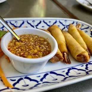a plate of spring rolls and dipping sauce