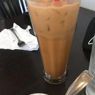 a glass of iced coffee with a red straw