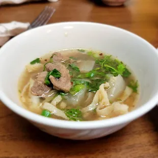 a bowl of soup with meat and vegetables