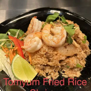 a plate of fried rice with shrimp and vegetables