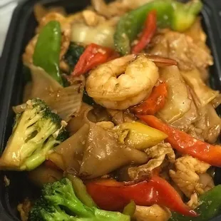 Drunken Noodle: A popular spicy wide rice noodle stir fried with chicken, shrimp, egg and vegetable in tasty spicy basil sauce.