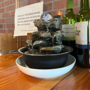 a water fountain and bottles of wine