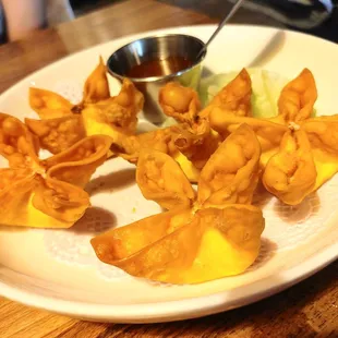 a plate of wontons with dipping sauce