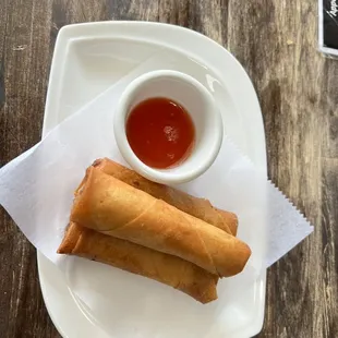 two fried spring rolls with dipping sauce