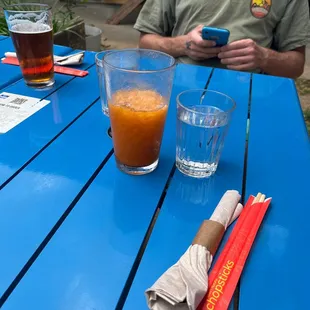 a man sitting at a blue picnic table