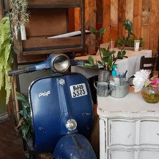 a blue scooter and a white chest of drawers