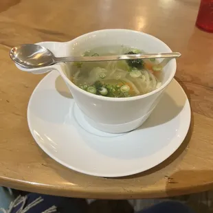 a bowl of soup and a spoon on a table