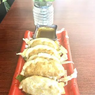 a plate of dumplings with dipping sauce