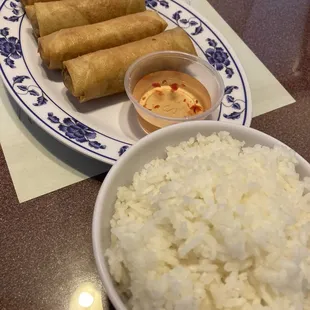 a plate of rice and a bowl of dipping sauce