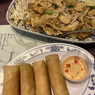 a plate of fried spring rolls and a bowl of dipping sauce