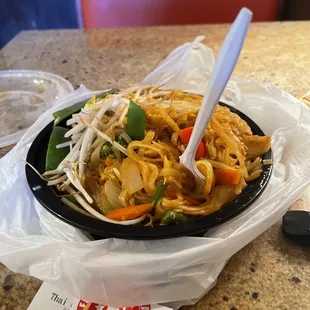 a bowl of noodles with chopsticks