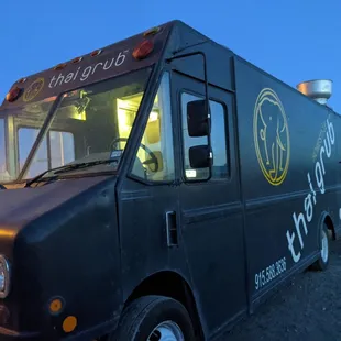 a black food truck parked on the side of the road