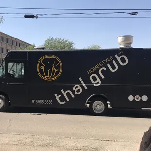 a black food truck on a city street