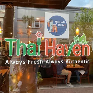 a man sitting at a table in front of a restaurant