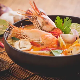 a bowl of soup with shrimp and vegetables