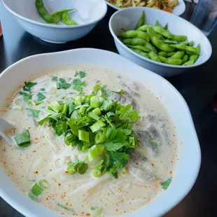 Beef Tom kha noodle soup (front plate), edamame, and pad see ew (back plate)