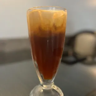 a glass of iced coffee on a table
