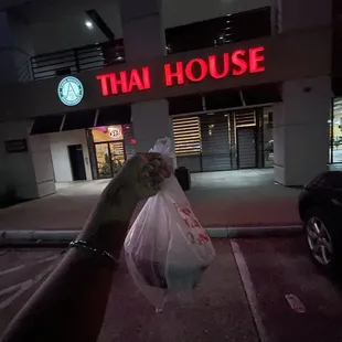 a hand holding a bag of food