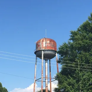 a rusted water tower in a rural area