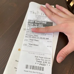 a hand holding a receipt