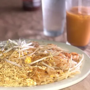 Shrimp pad Thai &amp; Thai iced tea (background)