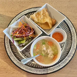 a bowl of soup, tortillas, and a salad