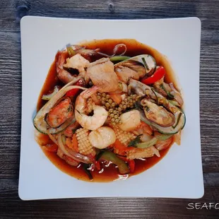 a plate of stir fried shrimp and vegetables