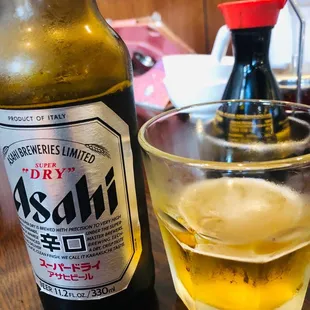 a glass of beer and a bottle on a table
