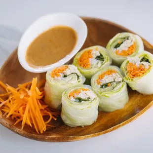 a plate of sushi rolls with dipping sauce