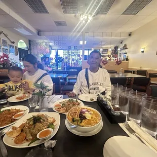 a man and a woman sitting at a table with plates of food