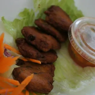 Tod mun. Fried curry fish cakes with dipping sauce.