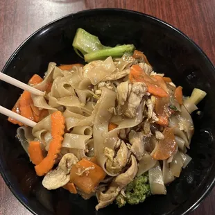 a bowl of noodles with carrots and broccoli