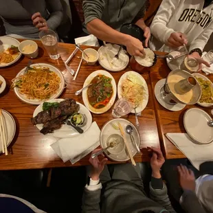 a group of people sitting at a table with plates of food