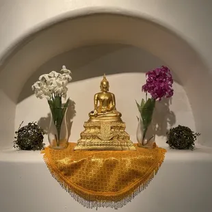 a buddha statue and flowers