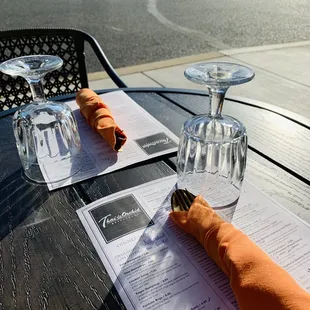 a table with a menu and wine glasses
