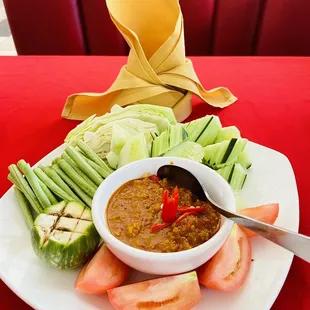 a plate of vegetables and dipping sauce