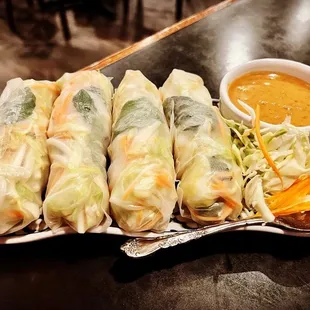 a plate of spring rolls with dipping sauce