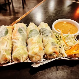 a plate of spring rolls with dipping sauce